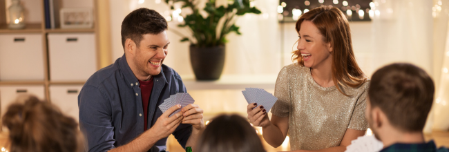 Family and friends.  together at a table playing board games. 